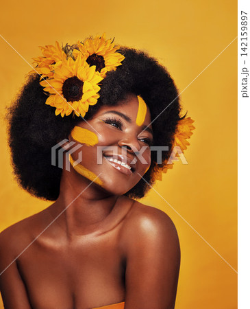 Black woman, plant and sunflower with skincare in studio for organic glow, dermatology or soft skin. Person, floral and confident with smile for natural, cosmetics and vitamin e on yellow background 142159897