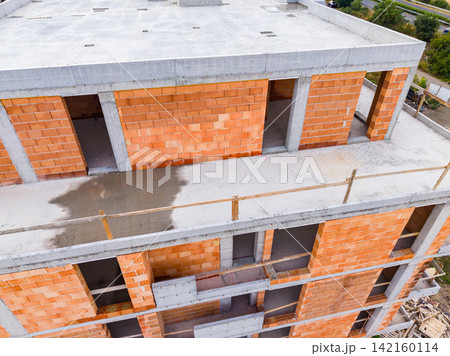Construction of a new building in an urban area showing brick walls and open spaces on multiple floors Construction of a new building in an urban area showing brick walls and open spaces on multiple floors 142160114