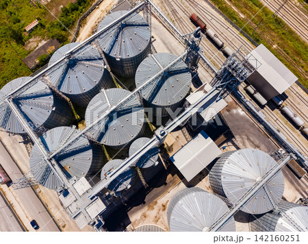 Storage silos are seen from above with trains in the background during the day in an industrial area Storage silos are seen from above with trains in the background during the day in an industrial area 142160251