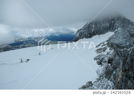 Dachstein glacier with ski lifts and misty mountain peaks Dachstein glacier with ski lifts and misty mountain peaks 142161528