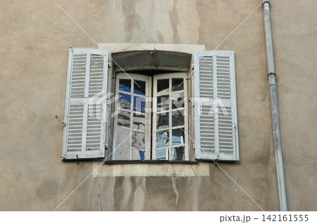 Old vintage window with white wooden shutters Old vintage window with white wooden shutters 142161555