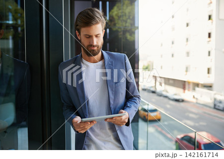 Business man, tablet and career on office balcony for web project, occupation review online and email feedback on digital report. Young male person or editor and tech for internet research on mockup 142161714
