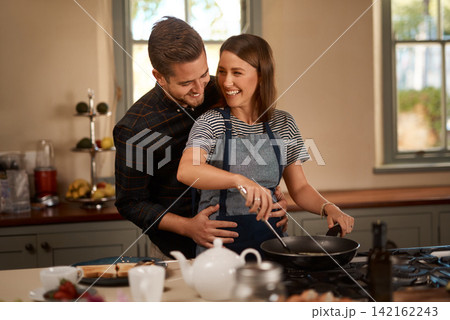 Happy, love and couple in kitchen for cooking, brunch or bonding with funny, conversation or hug at home. Food, diet and nutrition in house for breakfast, balance and meal prep with support or chat Happy, love and couple in kitchen for cooking, brunch or bonding with funny, conversation or hug at home. Food, diet and nutrition in house for breakfast, balance and meal prep with support or chat 142162243