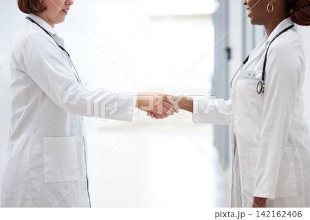 Female doctor and nurse, shaking hands for partnership, agreement and thank you for assistance. Happy, healthcare workers and handshake for teamwork, trust and support together in hospital or lab Female doctor and nurse, shaking hands for partnership, agreement and thank you for assistance. Happy, healthcare workers and handshake for teamwork, trust and support together in hospital or lab 142162406