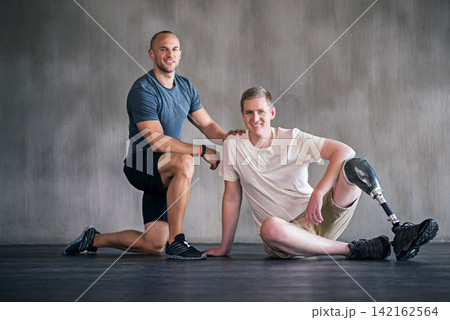 Trainer, person with a disability and prosthetic leg and posing in physiotherapy, studio and workout. Male people, physiotherapist and amputee for wellness, fitness and exercise in sports center Trainer, person with a disability and prosthetic leg and posing in physiotherapy, studio and workout. Male people, physiotherapist and amputee for wellness, fitness and exercise in sports center 142162564