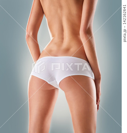 Body, legs and woman with lingerie in studio for wellness, care or feminine hygiene on grey background. Cotton, back and model with panty for ph balance, cleaning or sensitive cosmetics or product Body, legs and woman with lingerie in studio for wellness, care or feminine hygiene on grey background. Cotton, back and model with panty for ph balance, cleaning or sensitive cosmetics or product 142162641