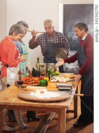 Cooking, taste and senior friends in kitchen for food, bonding or meal prep for reunion, birthday or weekend cookout in house. Diet, nutrition or class by old people learning traditional pasta recipe Cooking, taste and senior friends in kitchen for food, bonding or meal prep for reunion, birthday or weekend cookout in house. Diet, nutrition or class by old people learning traditional pasta recipe 142162792