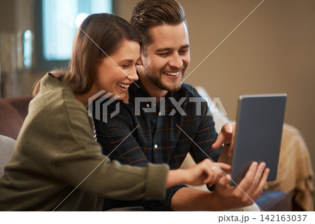 Home, relax and couple with tablet, love and search for vacation or social media post with tech in lounge. Apartment, funny or woman with man on sofa or smile with online reading, joke or digital app Home, relax and couple with tablet, love and search for vacation or social media post with tech in lounge. Apartment, funny or woman with man on sofa or smile with online reading, joke or digital app 142163037