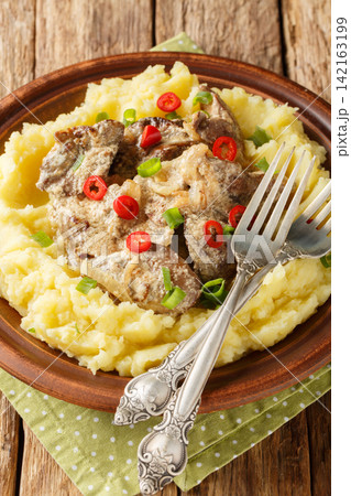 Fried chicken liver with cream sauce with mashed potatoes closeup on the plate. Vertical 142163199