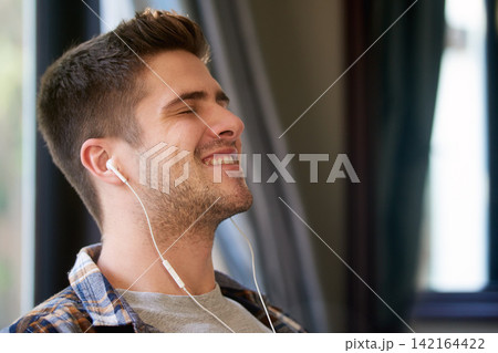 Man, earphones and happy with music for relax in home with radio, podcast or streaming audio for wellness. Person, smile and peaceful in living room with track, sound and comfortable with eyes closed 142164422