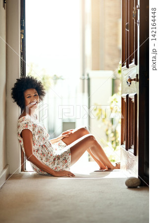 Black woman, happy and portrait sitting in doorway as cheerful, relax and peace for weekend in home. Female person, funny and apartment for calm, morning and playful with smile on floor for leisure Black woman, happy and portrait sitting in doorway as cheerful, relax and peace for weekend in home. Female person, funny and apartment for calm, morning and playful with smile on floor for leisure 142164448