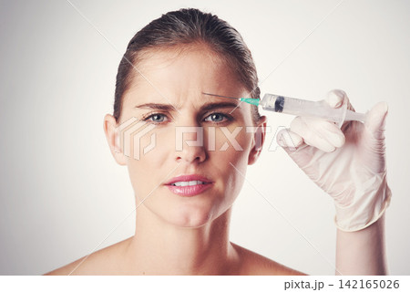 Woman, forehead and hand with syringe or glove for dermatology or skincare on a white studio background. Portrait, person and plastic surgery with needle for medical aesthetic, filler or facial Woman, forehead and hand with syringe or glove for dermatology or skincare on a white studio background. Portrait, person and plastic surgery with needle for medical aesthetic, filler or facial 142165026