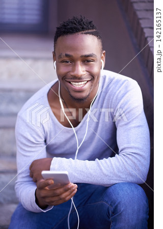 Black man, portrait and cellphone with earphones on stairs in city or music subscription, travel or relax. Male person, face and smartphone on downtown street in Atlanta or podcast, playlist or track Black man, portrait and cellphone with earphones on stairs in city or music subscription, travel or relax. Male person, face and smartphone on downtown street in Atlanta or podcast, playlist or track 142165137