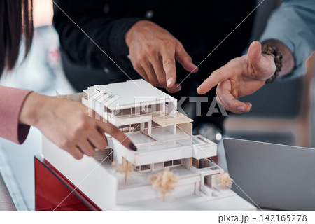 Hands, architect group and model of building with pointing for ideas, advice or planning for construction. People, engineering and property developer team in office with vision, design or creativity Hands, architect group and model of building with pointing for ideas, advice or planning for construction. People, engineering and property developer team in office with vision, design or creativity 142165278