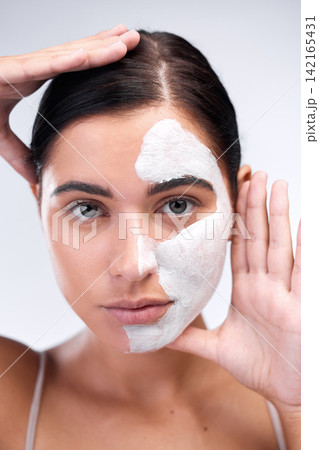 Woman, portrait and clay mask in studio, beauty and half skincare to exfoliate on white background. Female person, half cosmetics and acne or facial treatment, cleaning detox and comparison of result Woman, portrait and clay mask in studio, beauty and half skincare to exfoliate on white background. Female person, half cosmetics and acne or facial treatment, cleaning detox and comparison of result 142165431