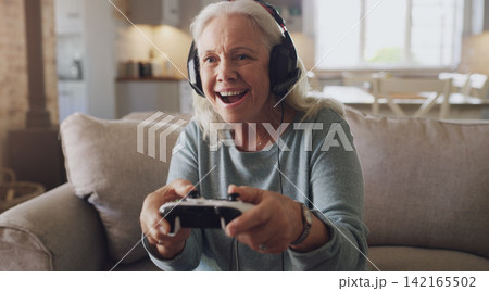 Headphones, senior woman and joystick for video game, online streaming and relax for retirement at home. Technology, elderly person and happiness with smile from esports, gaming and challenge on sofa Headphones, senior woman and joystick for video game, online streaming and relax for retirement at home. Technology, elderly person and happiness with smile from esports, gaming and challenge on sofa 142165502