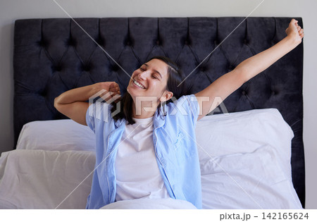 Morning, stretching and woman in bed with smile, wake up and getting ready for start of new day. Bedroom, happy face and girl in home with rest for calm routine, wellness and comfort in hotel room Morning, stretching and woman in bed with smile, wake up and getting ready for start of new day. Bedroom, happy face and girl in home with rest for calm routine, wellness and comfort in hotel room 142165624