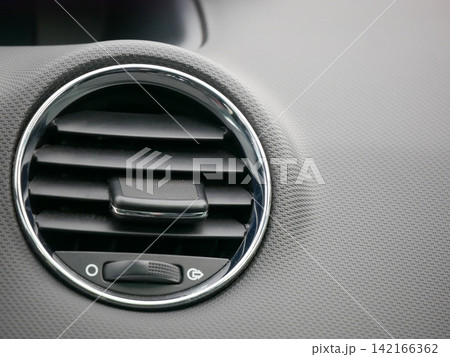 Close up view of car dashboard with air conditioning vent and airbag label. Interior detail of vehicle cockpit. Modern automobile design concept for automotive safety and comfort feature. Close up view of car dashboard with air conditioning vent and airbag label. Interior detail of vehicle cockpit. Modern automobile design concept for automotive safety and comfort feature. 142166362