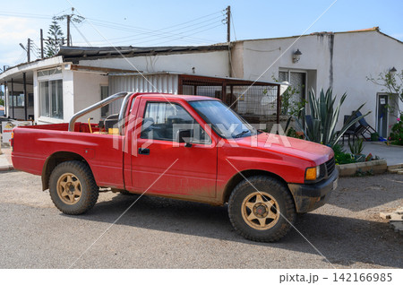 Vintage red pickup truck parked in a sunny neighborhood on a quiet day Vintage red pickup truck parked in a sunny neighborhood on a quiet day 142166985