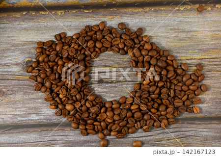 Creative coffee bean arrangement on weathered wood in a cozy setting evokes warmth and relaxation 142167123