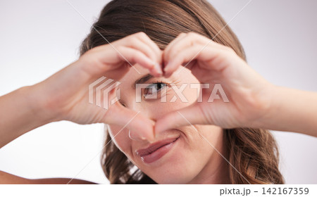 Woman, heart hands and sign for love in portrait, donation or charity with wellness and care on white background. Emoji, shape and romance gesture with thank you, feedback or reaction in studio 142167359