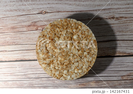 Top-down view of a round rice cake on a rustic wooden background Top-down view of a round rice cake on a rustic wooden background 142167431