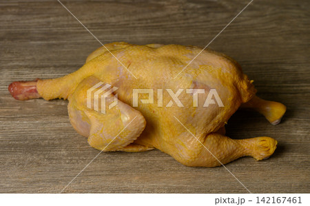 Whole Raw Yellow Chicken on Wooden Table Whole Raw Yellow Chicken on Wooden Table 142167461