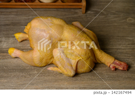 Whole Raw Yellow Chicken on Wooden Table Whole Raw Yellow Chicken on Wooden Table 142167494