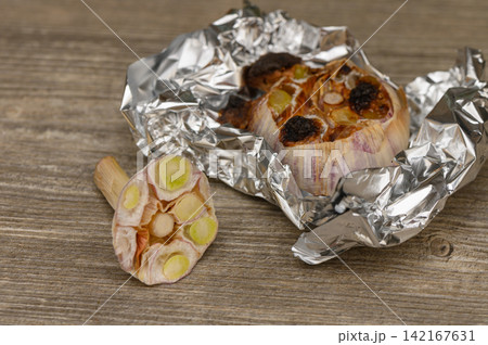 Roasted Garlic Head and Cross-Section Slice on Wood Roasted Garlic Head and Cross-Section Slice on Wood 142167631