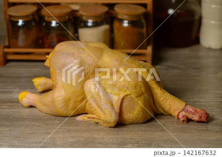Whole Raw Yellow Chicken on Wooden Table Whole Raw Yellow Chicken on Wooden Table 142167632