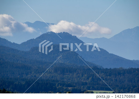 Cumulus clouds above the mountain ridge at the horizon. Vistara in the Gurktal valley, Carinthina, Austria, near Althofen. 142170868