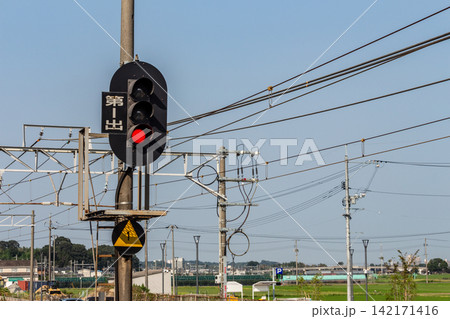 鉄道の信号機と架線柱、青空 142171416