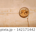 Rusty broken ceiling light fixture showing water damage 142171442