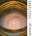 Burning candle illuminating warm light and cozy atmosphere 142171445