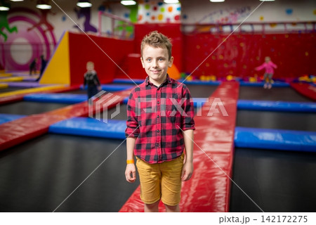 Boy standing on a safety mat at a trampoline park 142172275