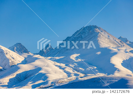 Majestic Snowy Mountain Range Under Clear Blue Sky 142172676
