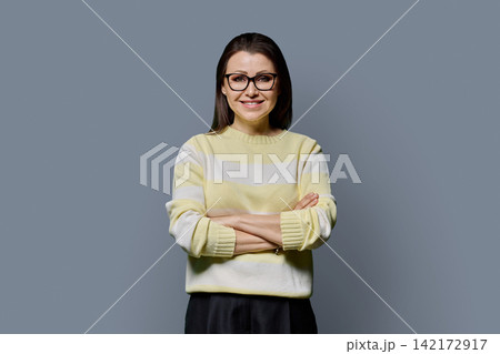 Confident smiling mature woman in glasses with arms crossed studio portrait Confident smiling mature woman in glasses with arms crossed studio portrait 142172917