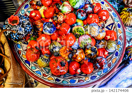 A brightly painted ceramic pomegranate, used for decoration in the Alcaiceria market of Granada.rightly painted ceramic pomegranate, used for decoration in the Alcaiceria market of Granada. A brightly painted ceramic pomegranate, used for decoration in the Alcaiceria market of Granada.rightly painted ceramic pomegranate, used for decoration in the Alcaiceria market of Granada. 142174406