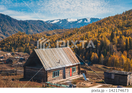 Autumn Mountain Landscape with Rustic Cabin and Golden Forest 142174673