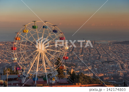 Ferris Wheel Over Barcelona City Skyline at Sunset Ferris Wheel Over Barcelona City Skyline at Sunset 142174803