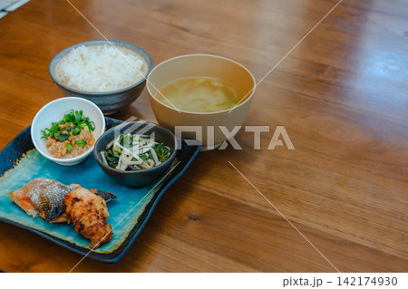 温かいご飯と味噌汁、焼き魚と納豆のバランスの取れた和朝食。 温かいご飯と味噌汁、焼き魚と納豆のバランスの取れた和朝食。 142174930