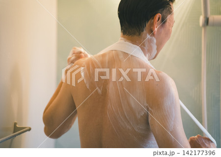 ボディタオルで背中をくまなく洗う男性のバスタイム ボディタオルで背中をくまなく洗う男性のバスタイム 142177396