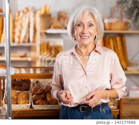 Mature female customer choosing bread and other delicious pastries in bakery Mature female customer choosing bread and other delicious pastries in bakery 142177698