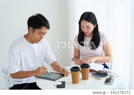 タブレットPCとテキストを使って勉強する男女 142178171