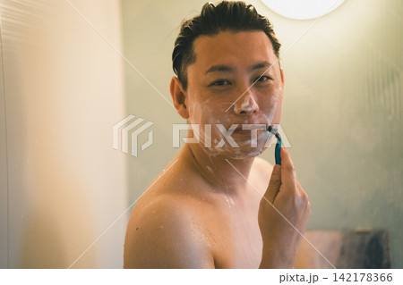 笑顔でひげを剃る40代男性のバスタイム 142178366