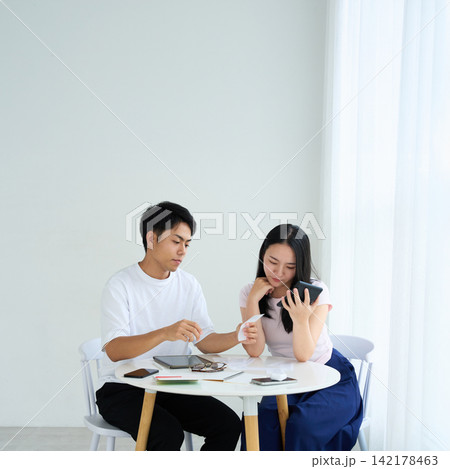 家計を相談する若い男女 142178463