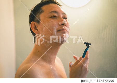 笑顔でひげを剃る40代男性のバスタイム 142178550