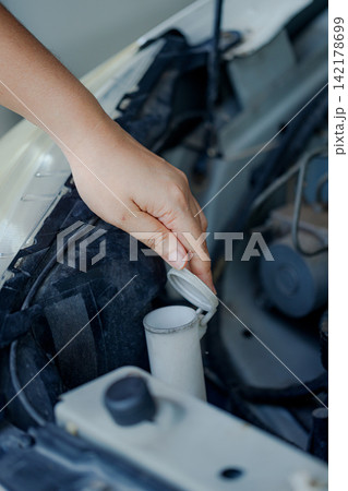 Close up of a hand of woman is checking a liquid coolant pot 142178699