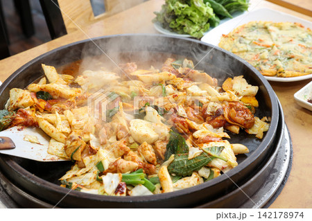 Spicy Korean Chicken Stir Fry Dakgalbi with Vegetables on Iron Pan Spicy Korean Chicken Stir Fry Dakgalbi with Vegetables on Iron Pan 142178974
