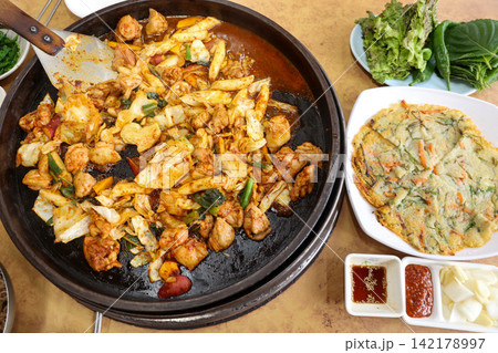 Spicy Korean Chicken Stir Fry Dakgalbi with Vegetables on Iron Pan Spicy Korean Chicken Stir Fry Dakgalbi with Vegetables on Iron Pan 142178997